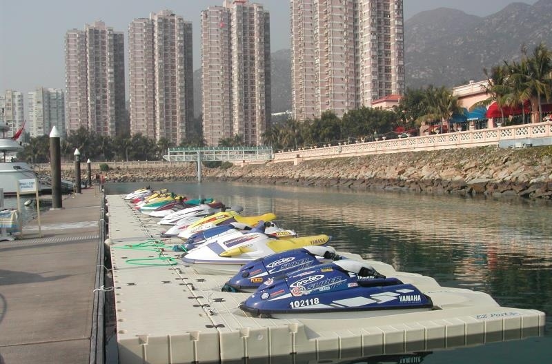 HDPE Modular Floating Pontoon Dock For Jet Ski Marina Berth Rotomolded HDPE floating pontoon dock with jet skis parked at coastal marina, modular plastic floating dock for watercraft mooring